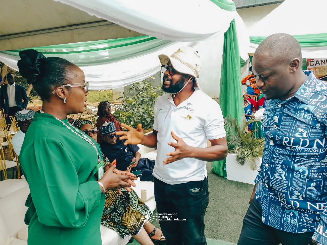Farmer Timothy in the centre and Eric on the right speaking with one of the organisers at the event