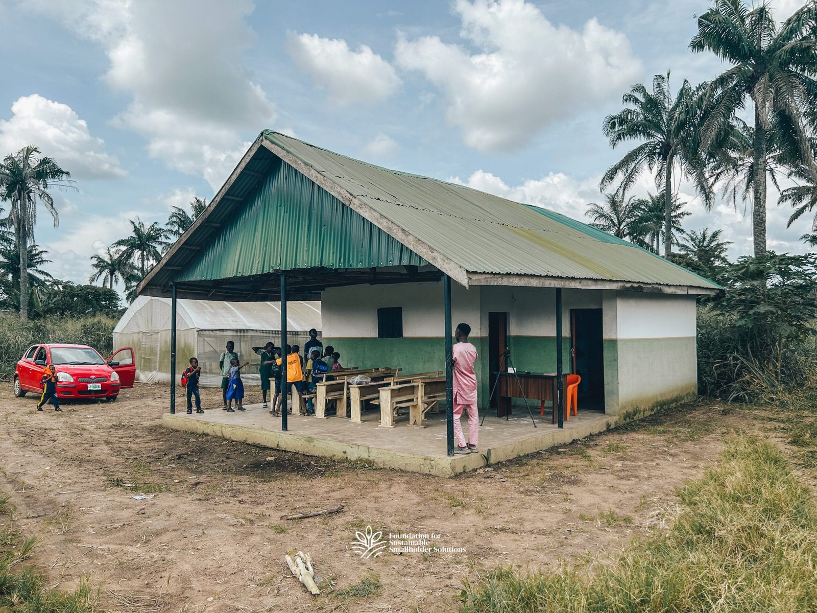 Front-view of the Farmers' Hub with school pupils and the hub manager