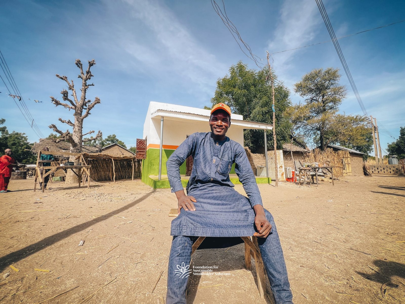 Auwalu Umar sits and smiles in front of the newly constructed Farmers’ Hub in Diga community, Itas-Gadau, Bauchi State.